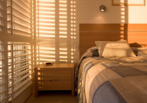 Beautiful golden light filtering through shutters in a bedroom