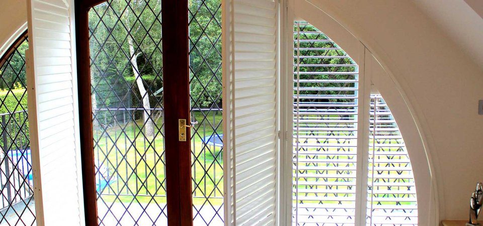 Bespoke Shaped Shutters in a bedroom