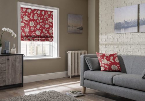 red floral roman blinds in living room with matching cushion